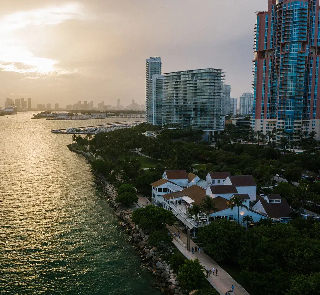 Casas frente al agua y torres en la bahía de Biscayne al atardecer