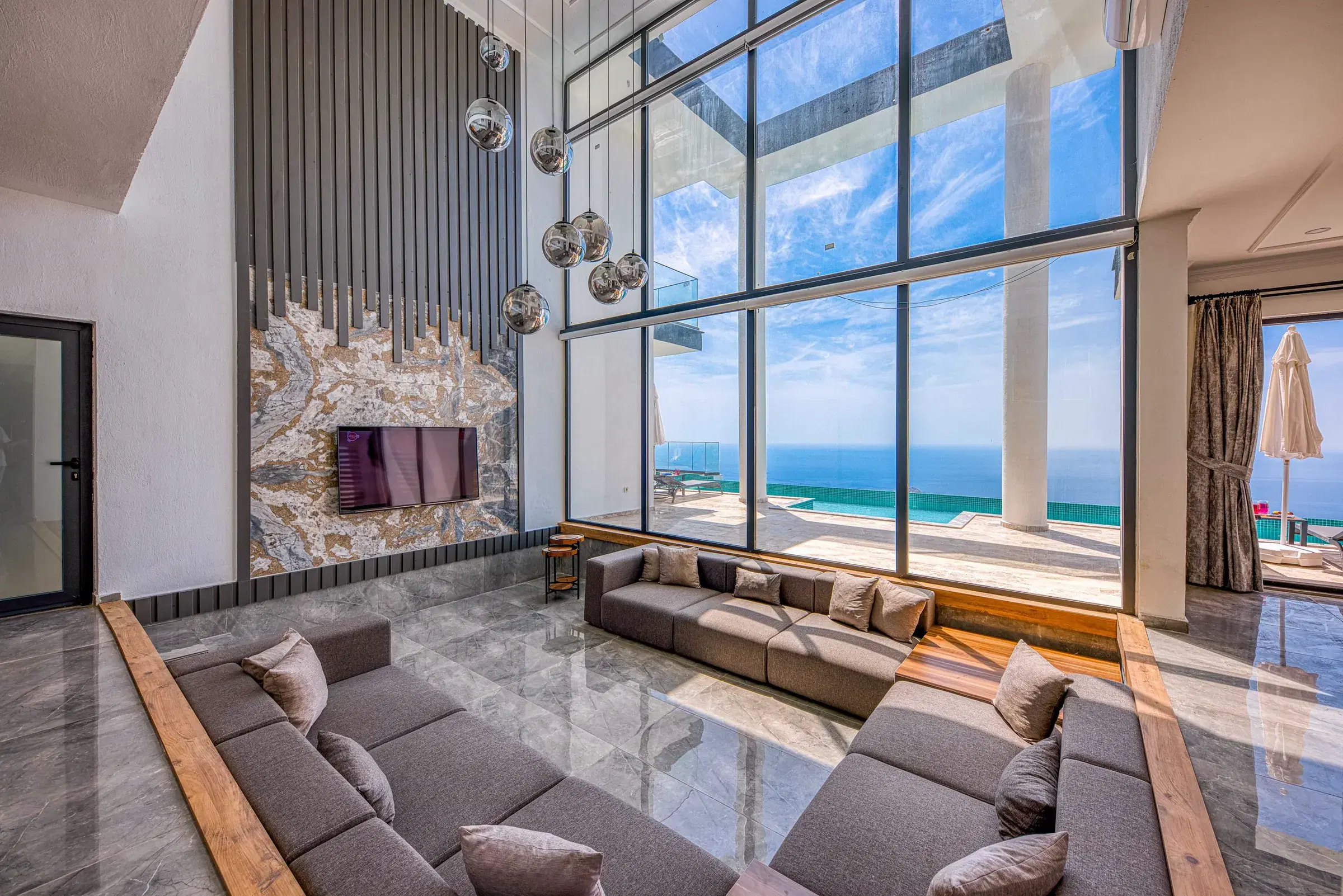 Sala luminosa con ventanales de piso a techo frente al mar