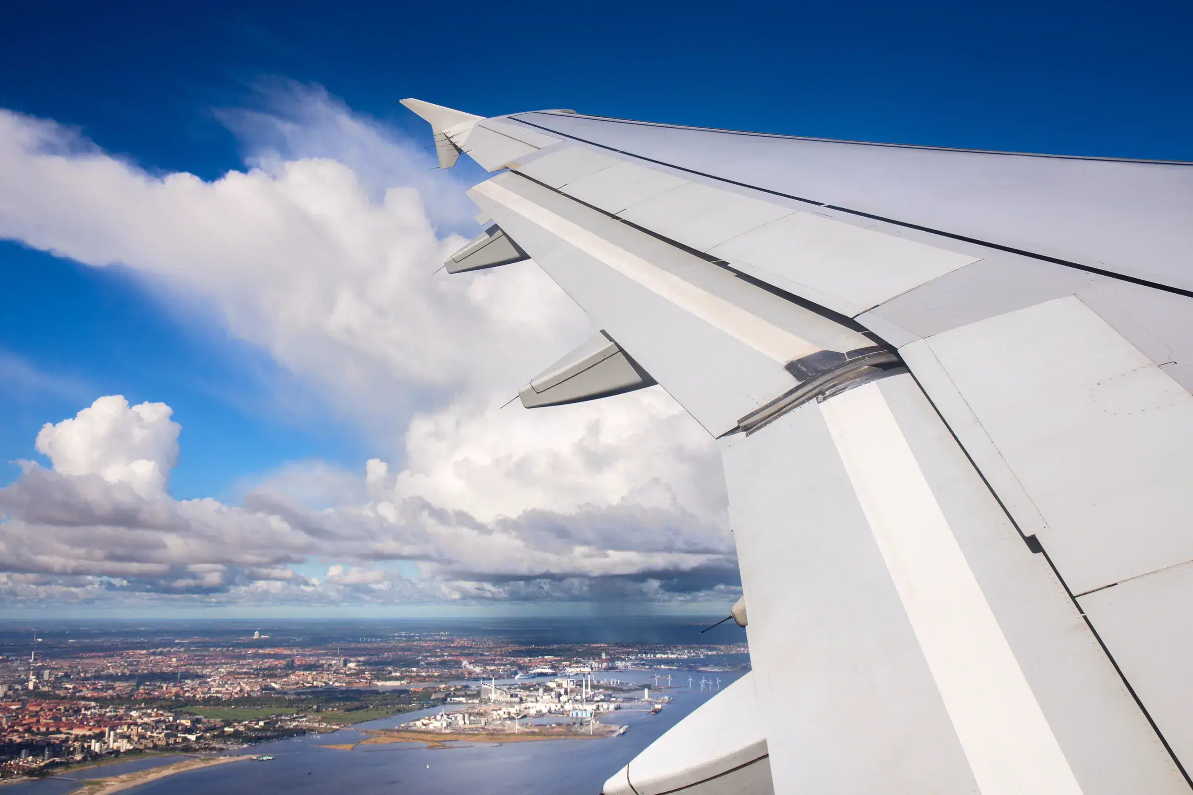 Vista de las nubes y una ciudad desde la ventana de un avión